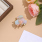 Beau vibrant acetate hair clip photographed with soft shadows on white background