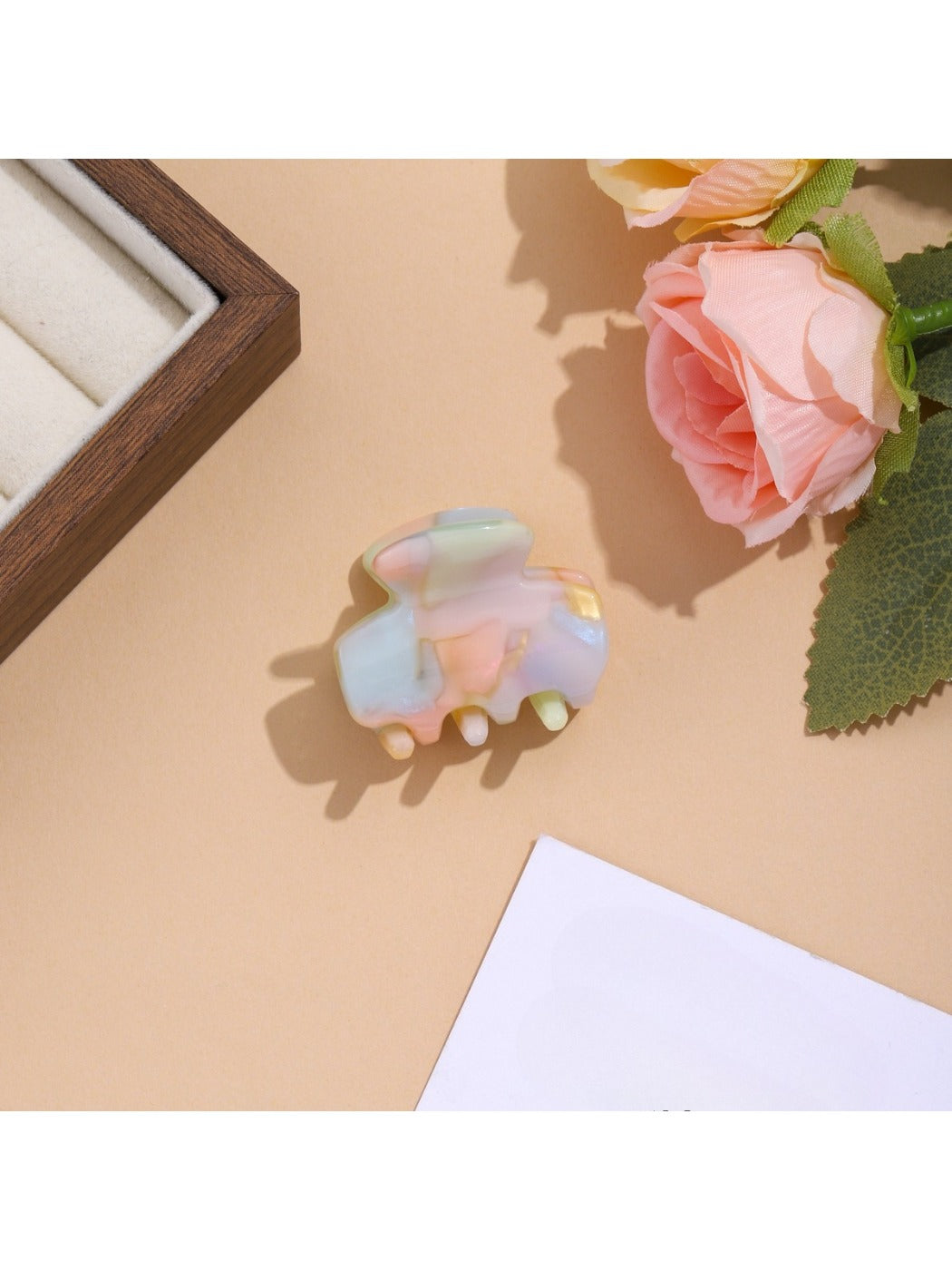 Beau vibrant acetate hair clip photographed with soft shadows on white background