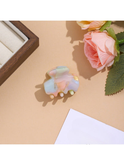 Beau vibrant acetate hair clip photographed with soft shadows on white background
