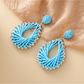 Close-up of earring hook and raffia geometric drop detail