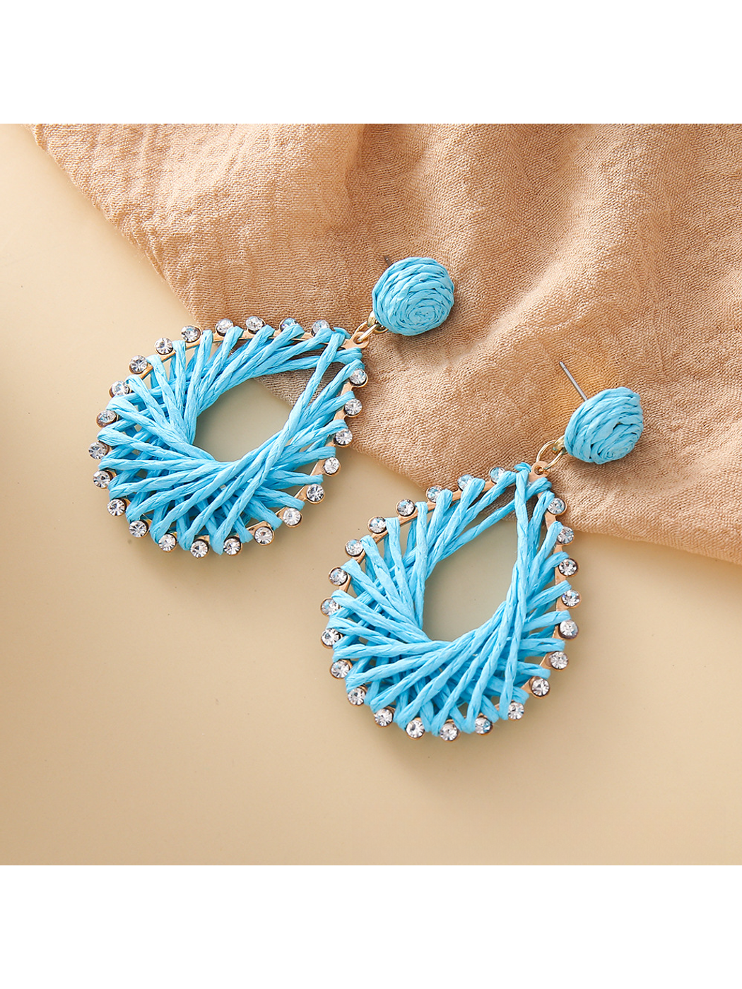 Close-up of earring hook and raffia geometric drop detail