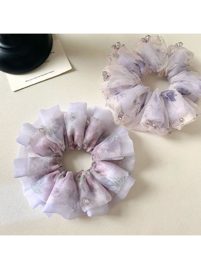 Close-up of Gifty elegant purple scrunchie with floral print on fabric