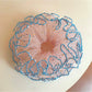 Close-up of a pink four-layer ruffled scrunchie with soft fabric texture