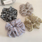 Gifty scrunchie with small white and yellow daisy pattern on light fabric