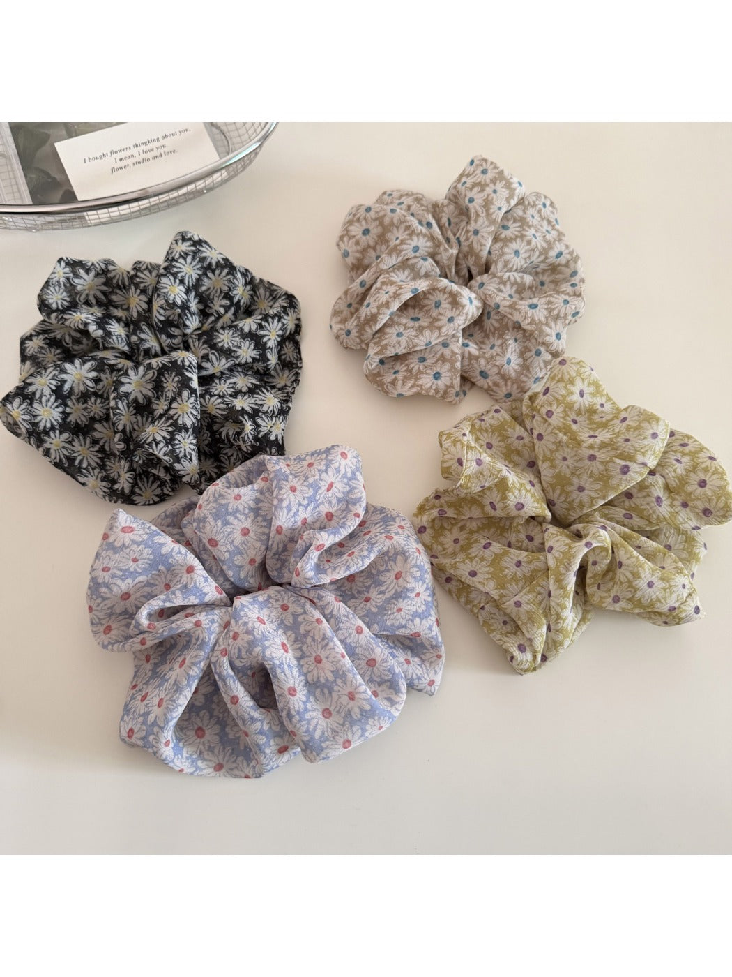 Gifty scrunchie with small white and yellow daisy pattern on light fabric