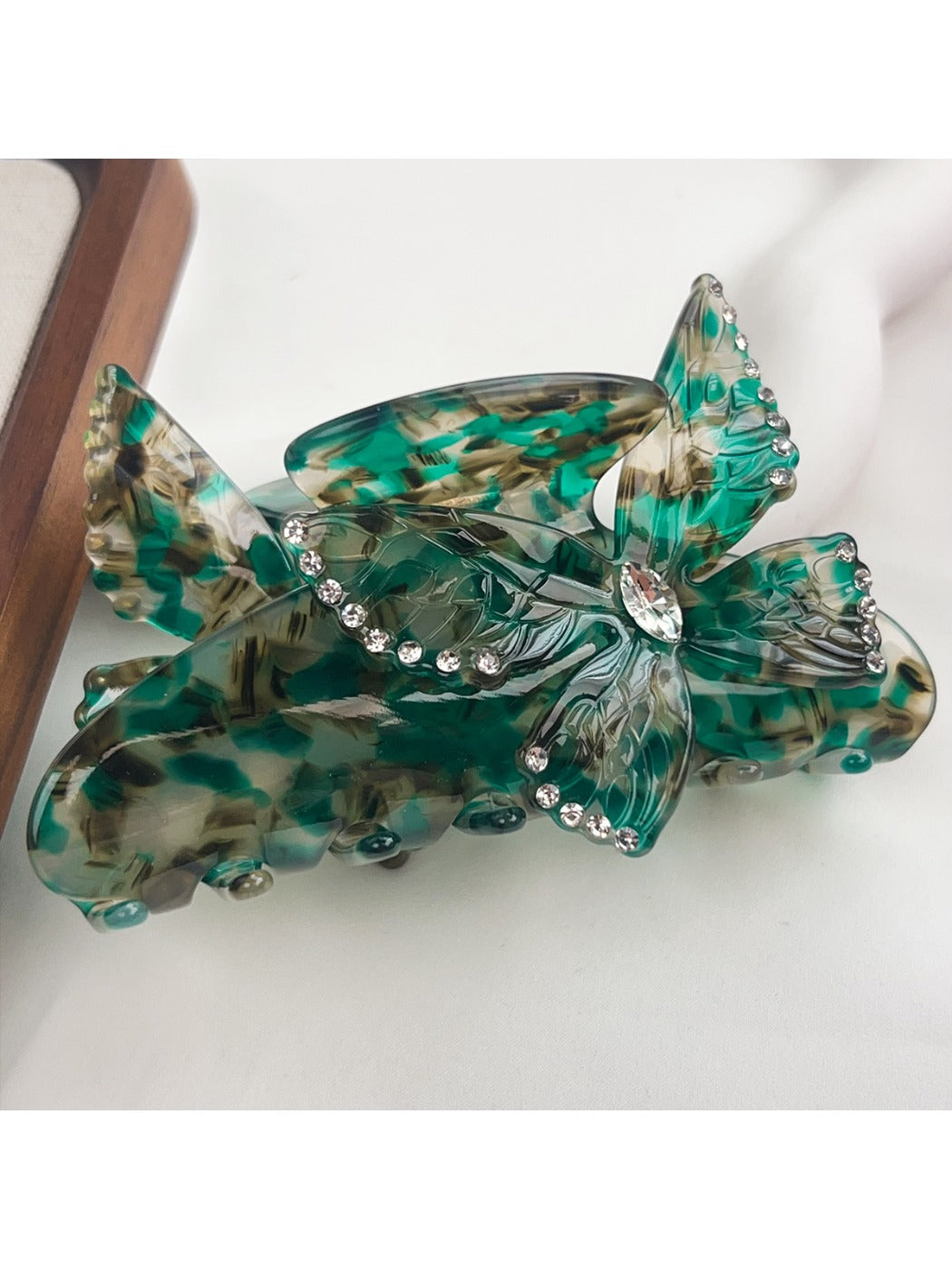Beau hair claw clip with vibrant butterfly patterns on a neutral background