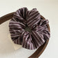Gifty dark striped scrunchie displayed with matching accessories