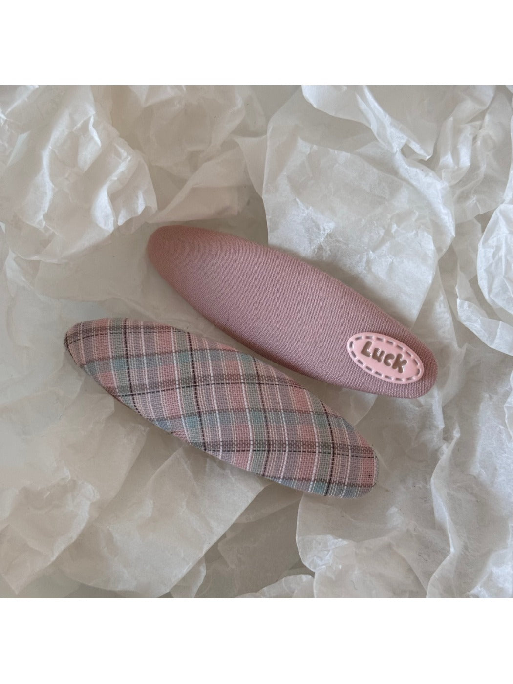 Beau colorful oval hair clip placed on a wooden surface with natural lighting