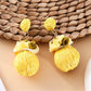 Pair of Earedge fabric flower raffia ball earrings with gold-tone hooks