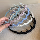 Gifty polka dot toothed comb headband in black with white dots, front view