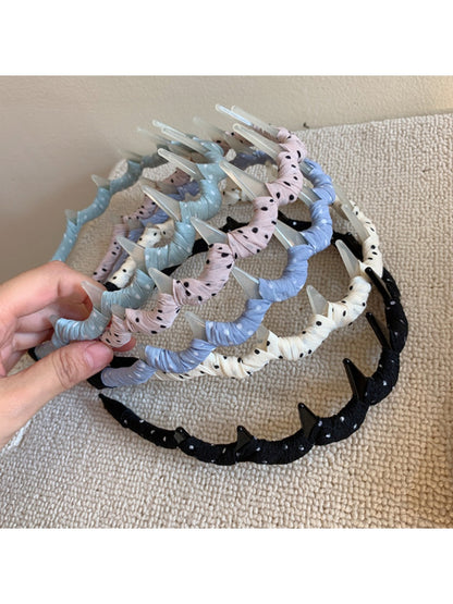 Gifty polka dot toothed comb headband in black with white dots, front view