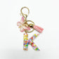 Keychain with butterfly and letter pendant placed on a fabric background