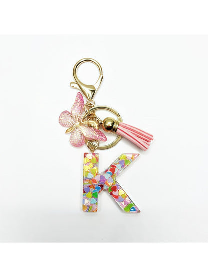 Keychain with butterfly and letter pendant placed on a fabric background