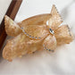 Beau hair claw clip open showing spring mechanism and butterfly design