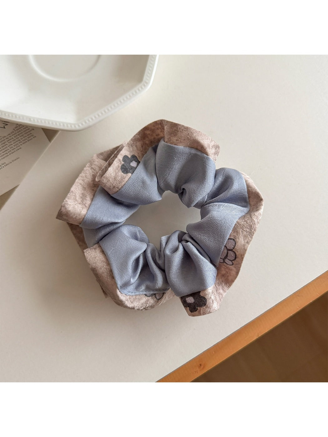Flat lay of Gifty ruffle scrunchie with color block print on a neutral surface