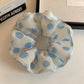 Gifty scrunchie styled on a wrist showing its elastic and fabric texture