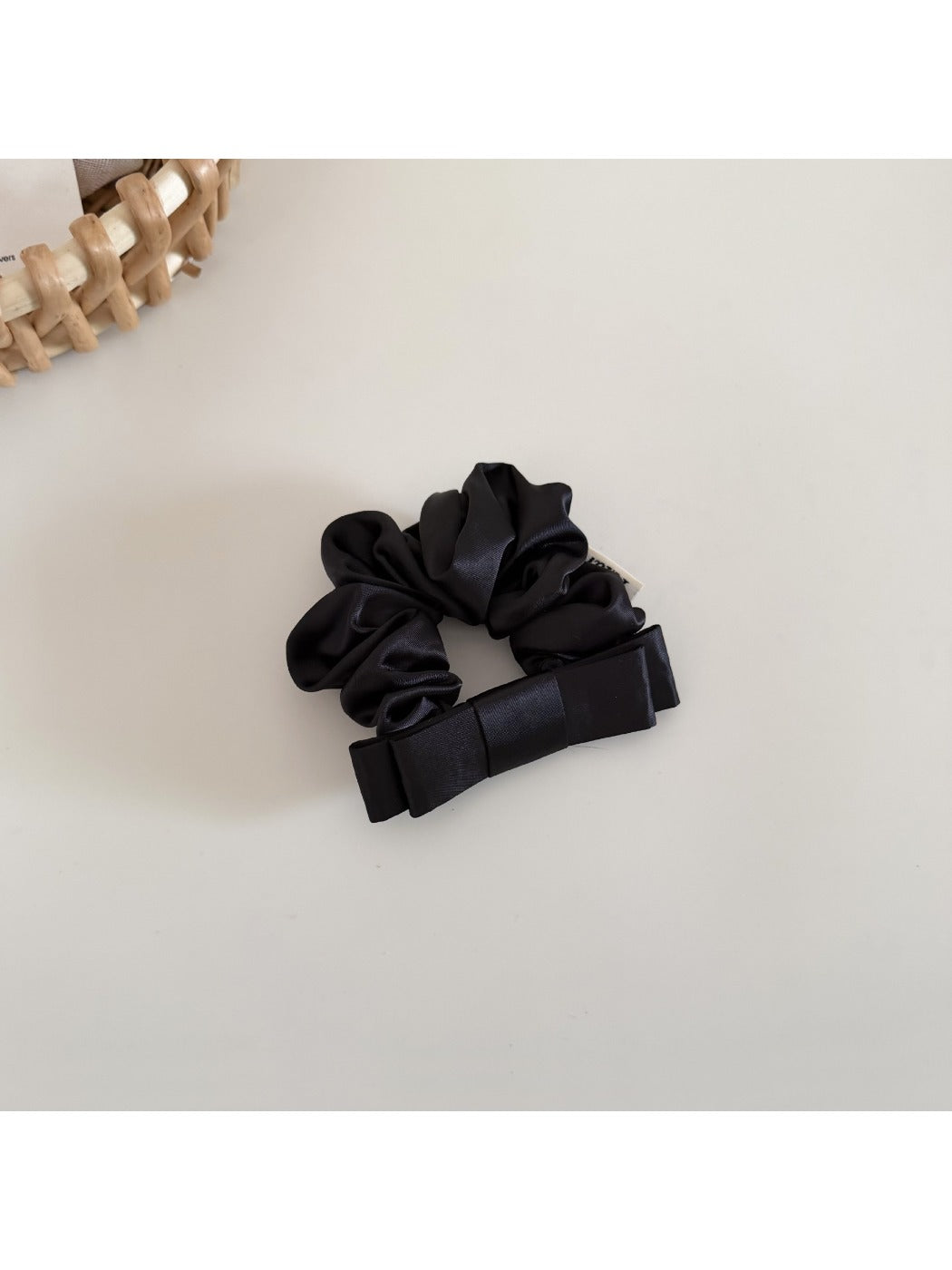 Close-up of the satin bow scrunchie fabric texture and stitching details
