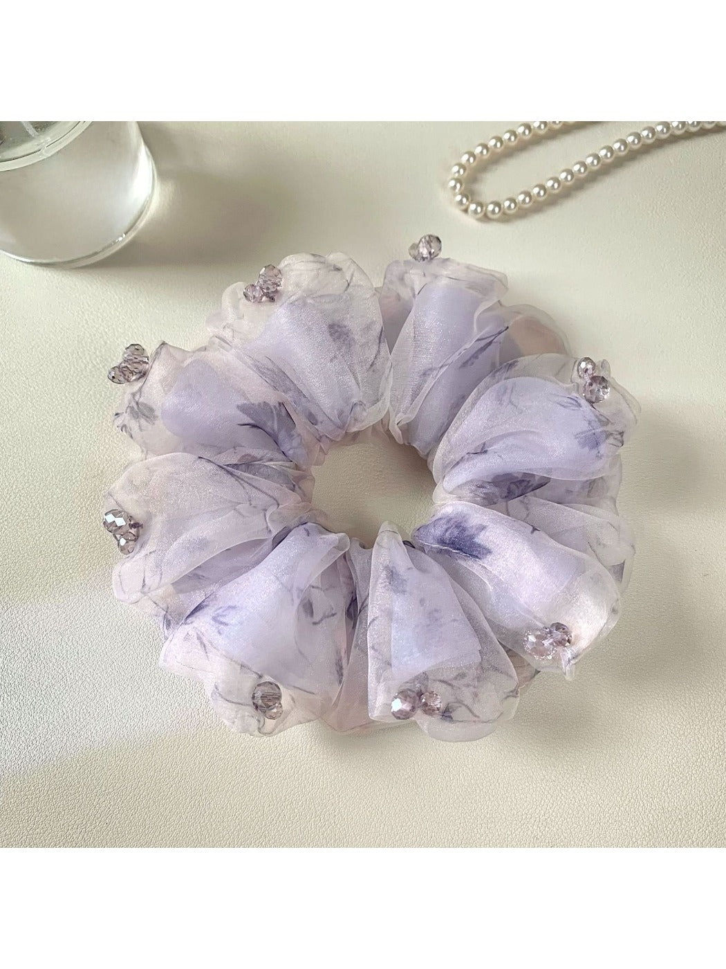 Gifty purple floral scrunchie lying flat with visible elastic band inside