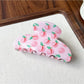Top view of Beau fruit print acrylic claw clip showing curved shape