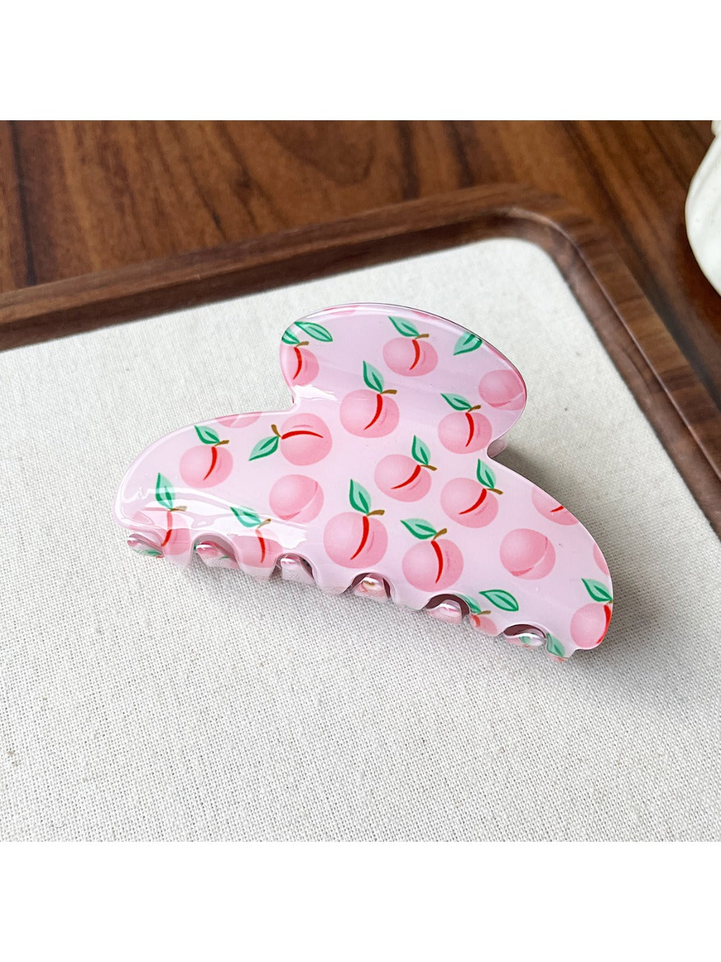 Top view of Beau fruit print acrylic claw clip showing curved shape