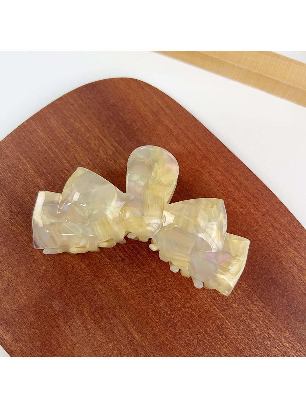 Beau bow shaped hair claw clip in beige with metal spring visible