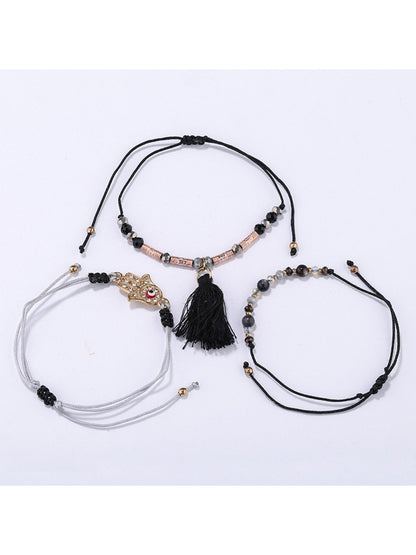 Close-up of Lovra alloy charm with tassel pendant on bracelet