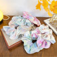 Gifty ruffled scrunchie displayed on a white background showing its texture and colors