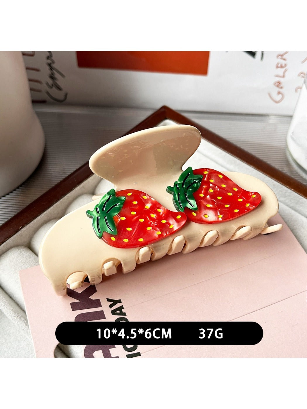 Yellow fruit shaped claw clip held between fingers