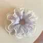 Close-up of a sweet purple ruched scrunchie made from soft fabric