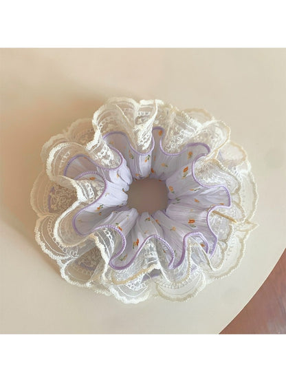 Close-up of a sweet purple ruched scrunchie made from soft fabric