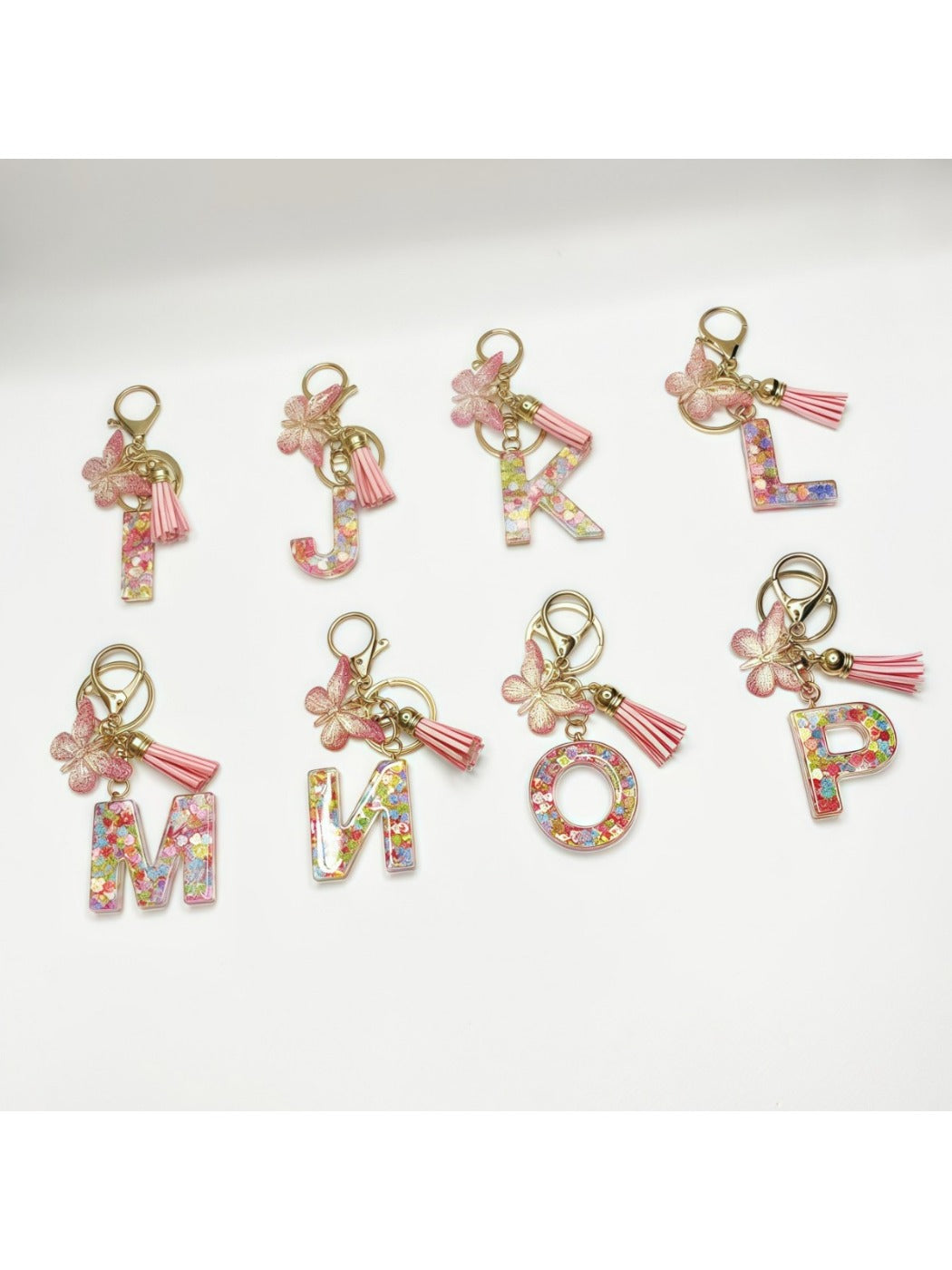 Butterfly and letter pendant keychain displayed on a wooden surface