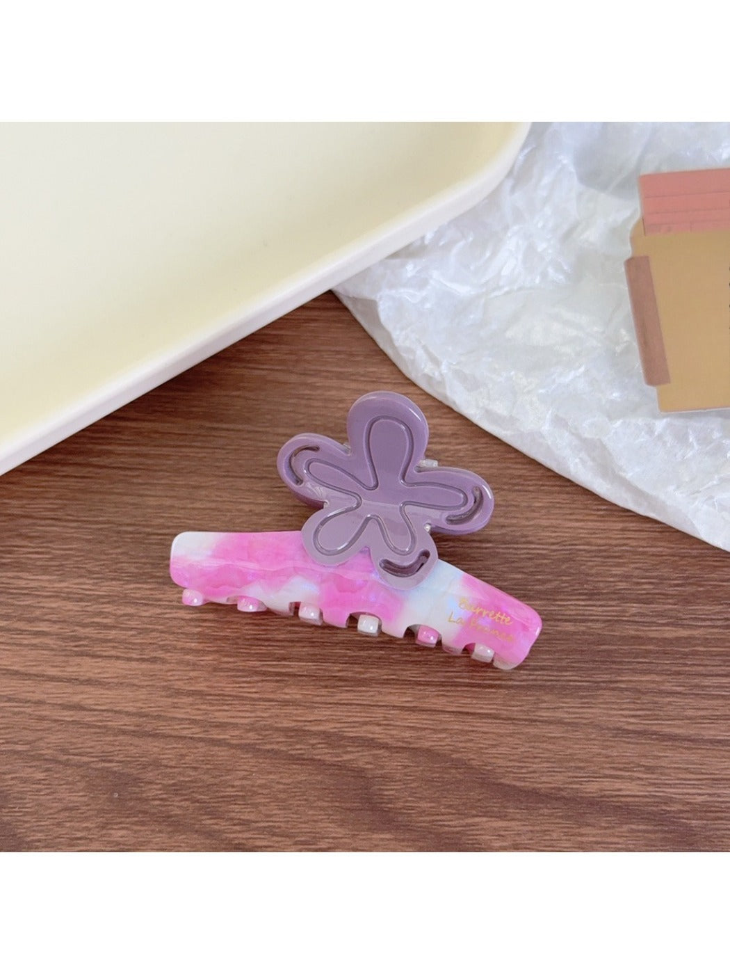 Beau flower shaped claw clip next to matching pastel accessories