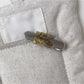 Beau vintage flat hair clip placed on textured fabric background
