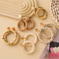 Close-up of Earedge rattan woven round hollow earrings on white background