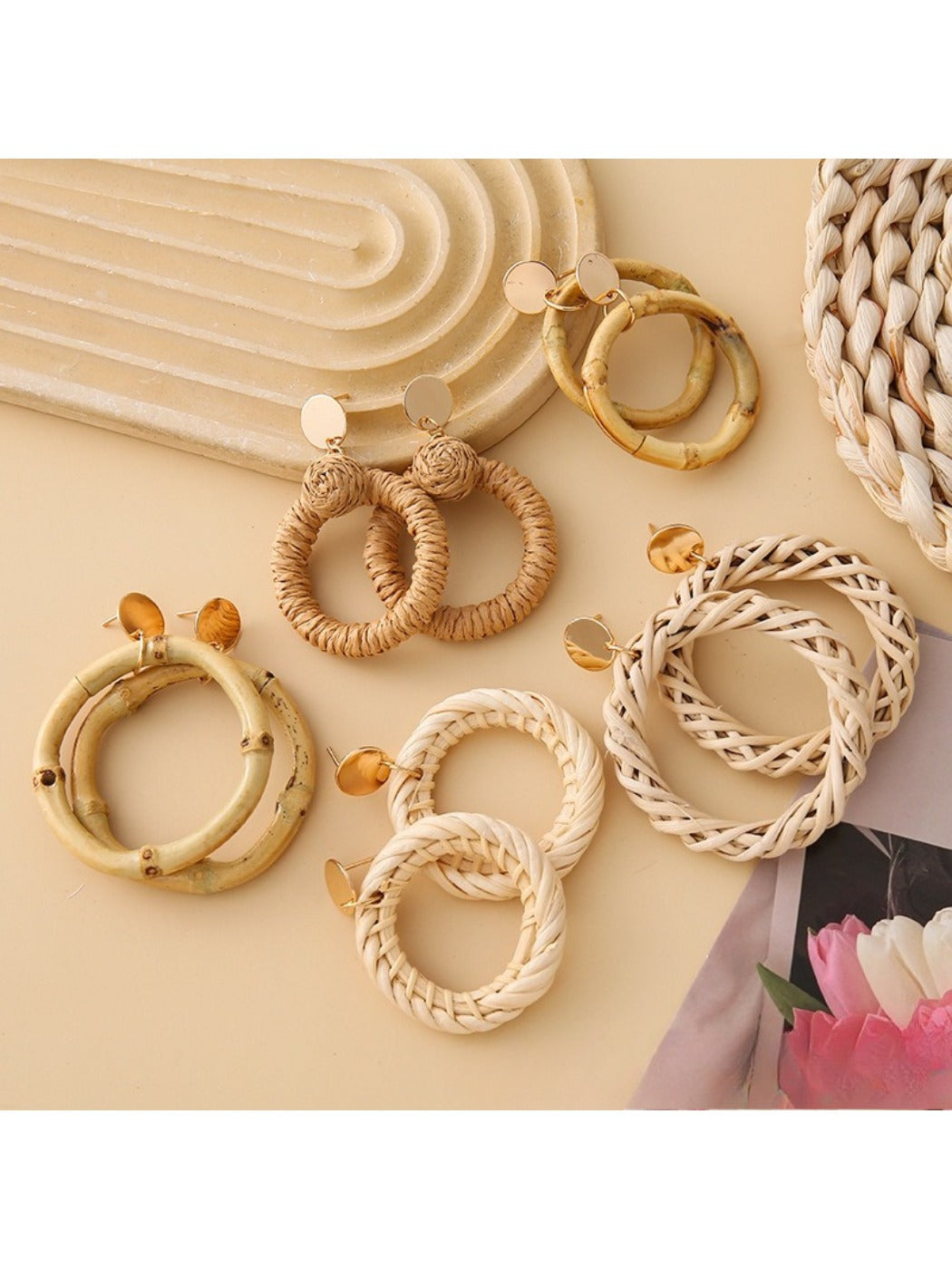 Close-up of Earedge rattan woven round hollow earrings on white background