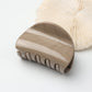 Beau half circle hair clip displayed on a wooden surface with soft lighting
