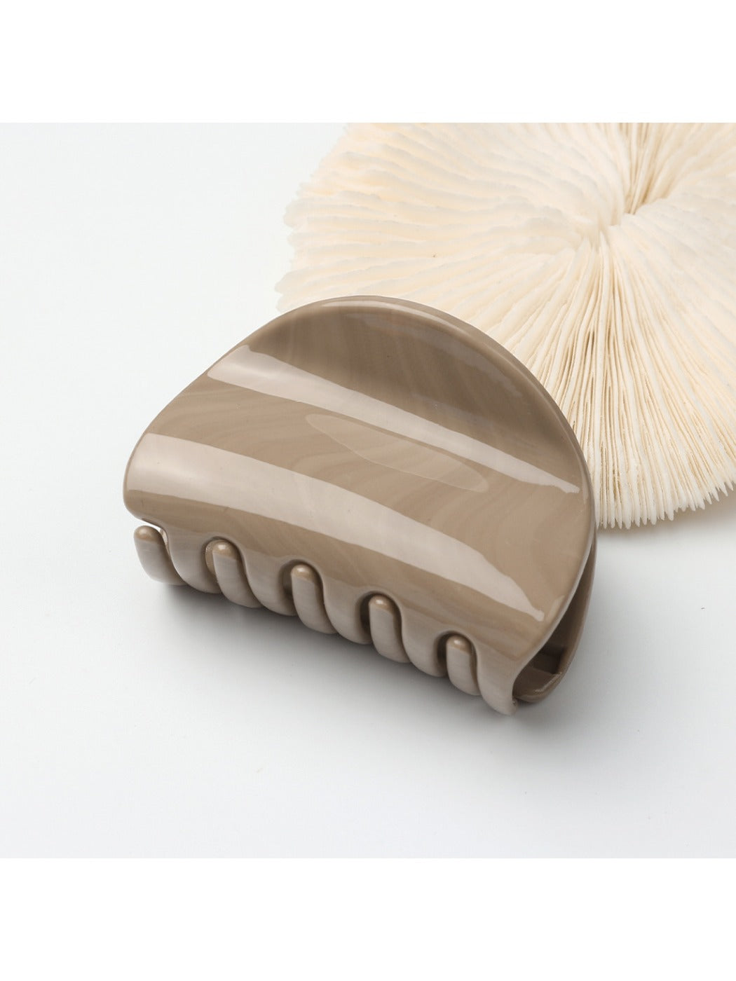Beau half circle hair clip displayed on a wooden surface with soft lighting