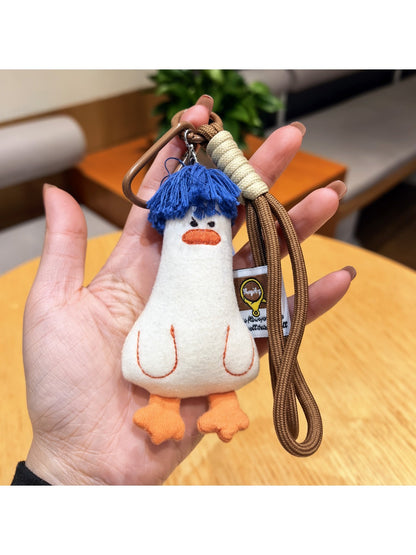 Blue duck keychain attached to a silver keyring on a plain surface