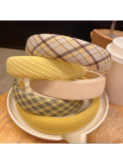 Close-up of yellow fabric headband showing texture and bow design