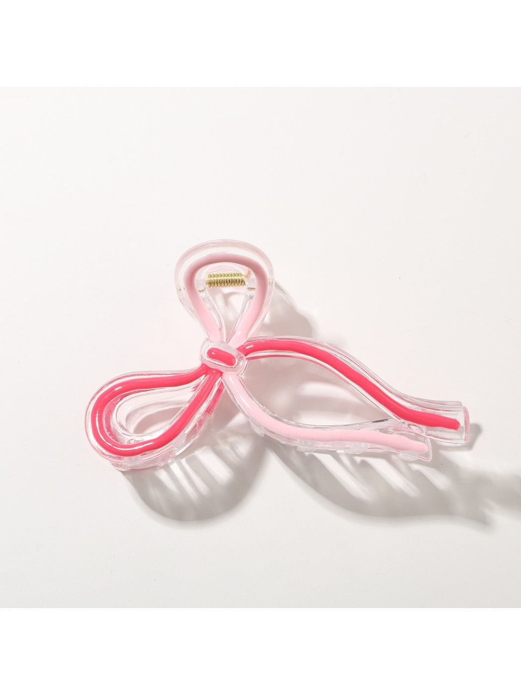 Beau Sweet Ribbon Knot Hair Clip clipped onto a strand of hair, demonstrating size