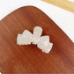 Beau hair claw clip placed next to matching hair accessories
