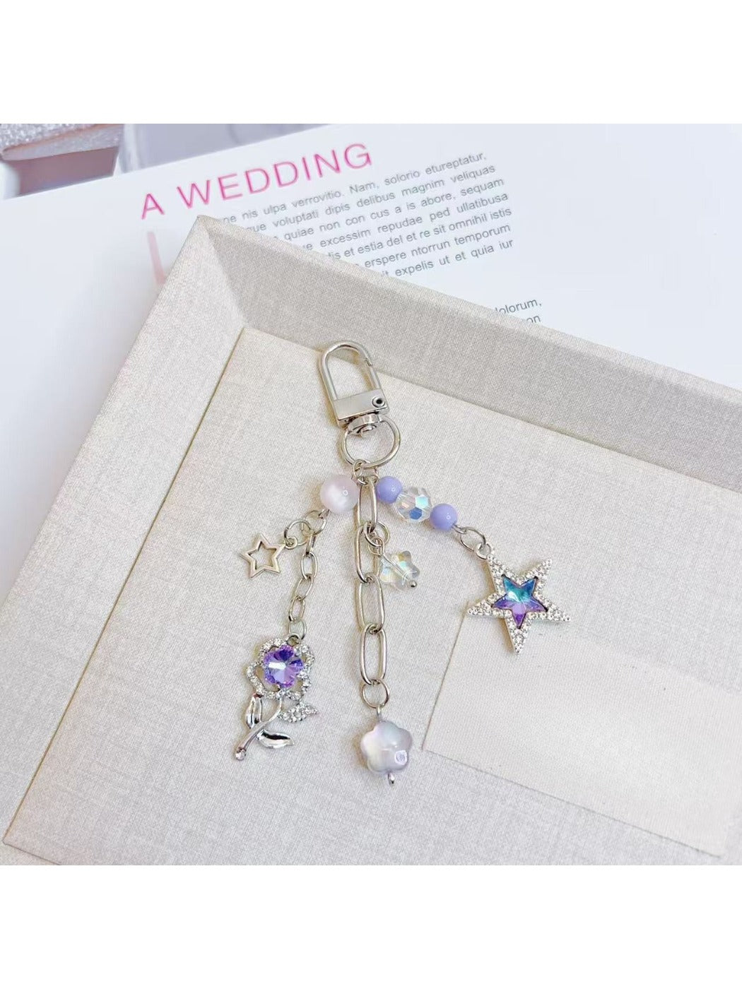 Silver keyring attached to purple star flower charm keychain