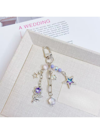 Silver keyring attached to purple star flower charm keychain