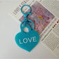 Pink heart-shaped pendant keychain displayed on a white surface