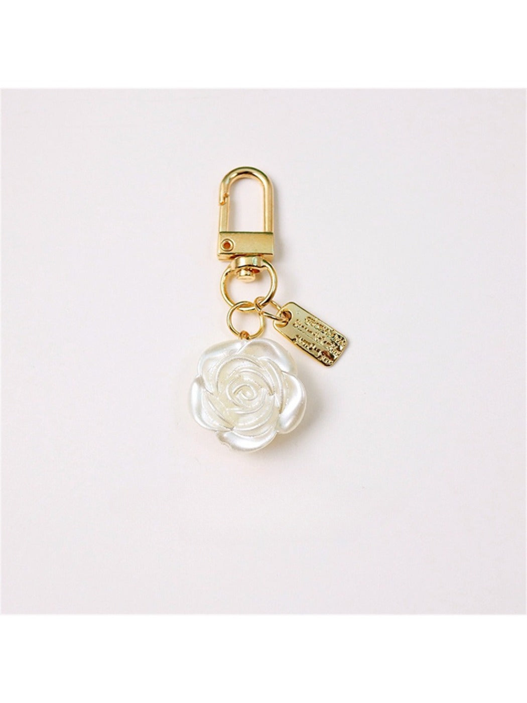 Flat lay of Keypus beaded bow charm keychain with gold ring and vibrant beads on fabric