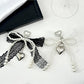 Close-up of a lace bow shaped keychain in soft pink with a gold keyring
