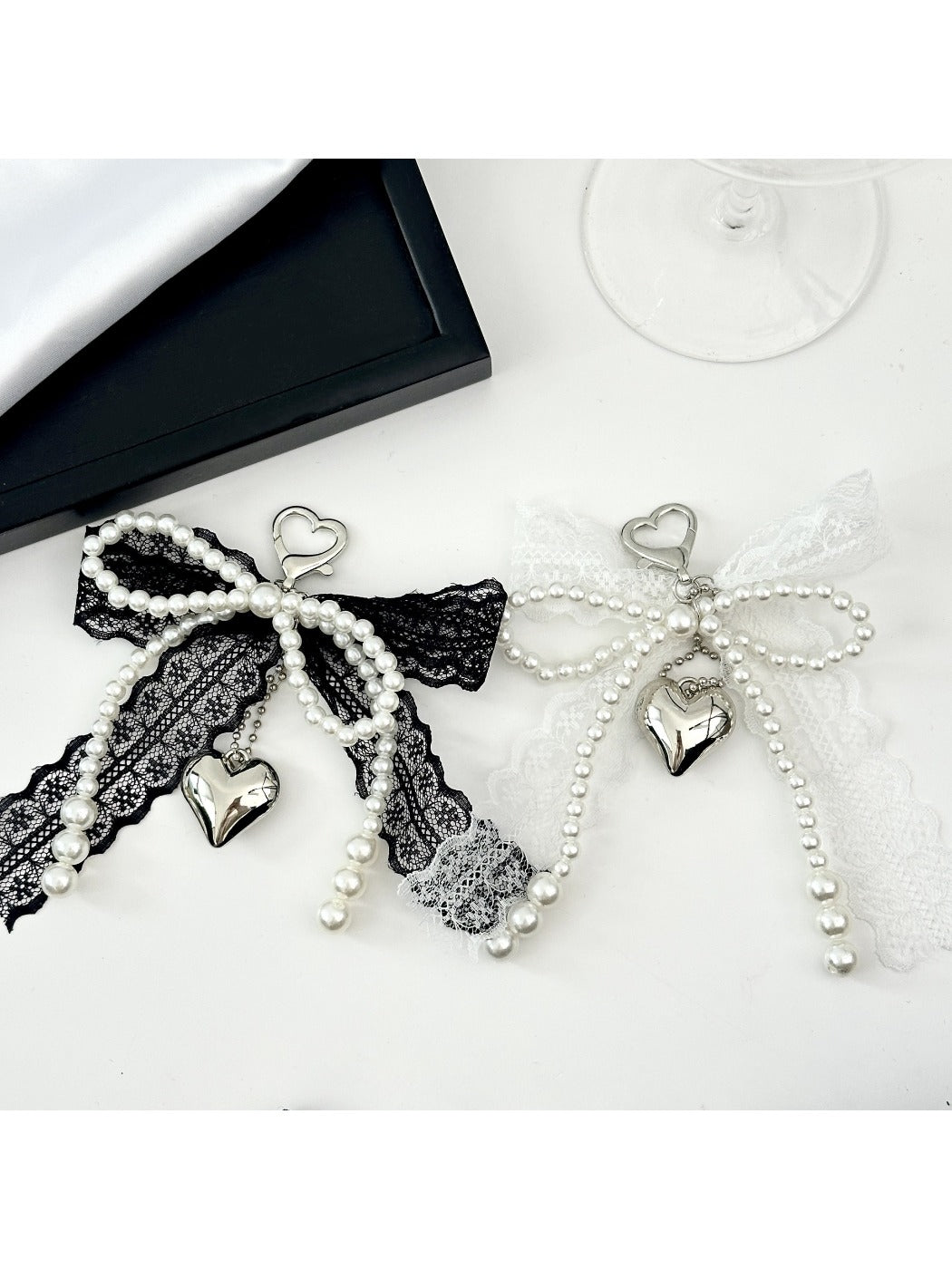 Close-up of a lace bow shaped keychain in soft pink with a gold keyring