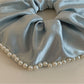 Gifty satin scrunchie with pearl beads displayed on a wooden surface