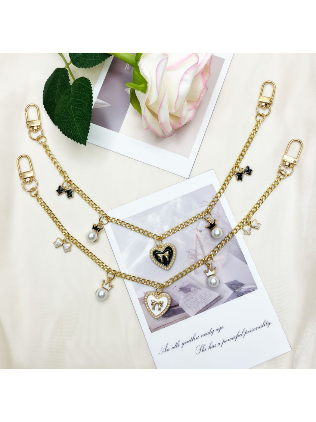 Heart bow pendant bag charm attached to a beige handbag strap