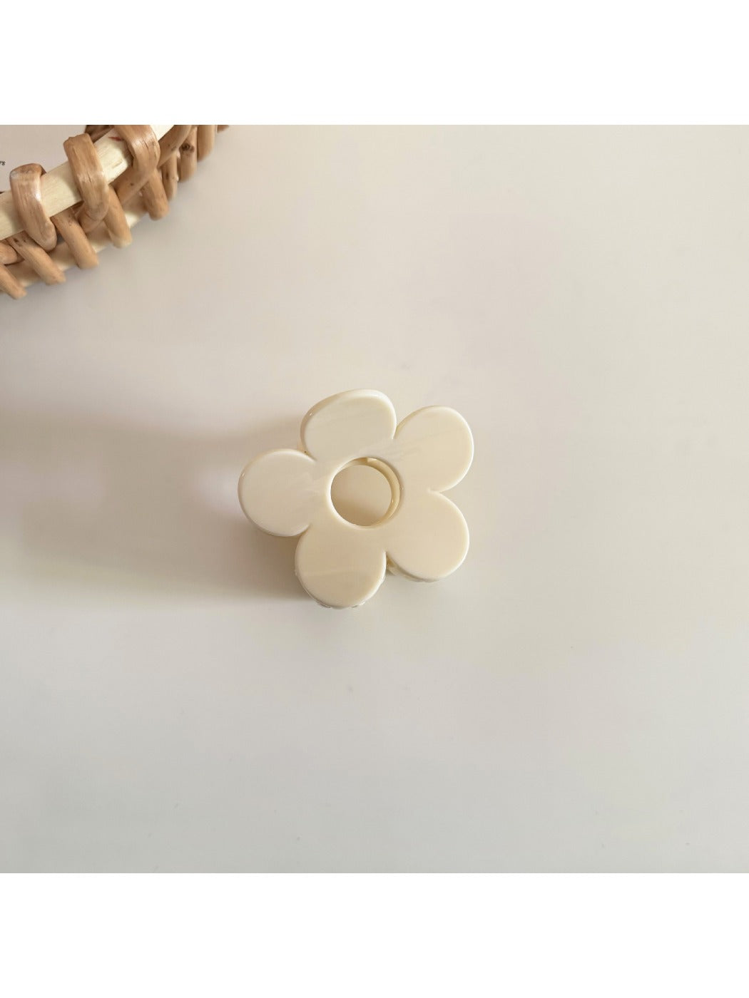 Beau flower hair clip held in hand to show scale and natural material texture